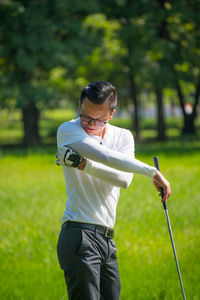 Mid adult man standing at golf course