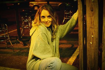 Portrait of a smiling young woman sitting outdoors