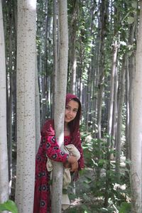 Portrait of afghan girl standing in forest