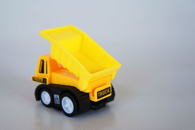 Close-up of yellow toy car over white background