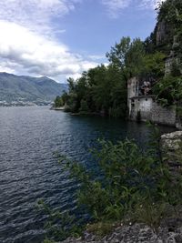 Scenic view of river by buildings against sky