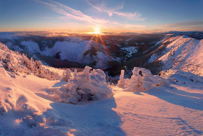 Scenic view of snow covered mountains against sky during sunset