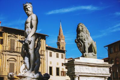 Low angle view of statue against buildings