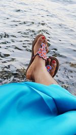 Low section of person relaxing on sea