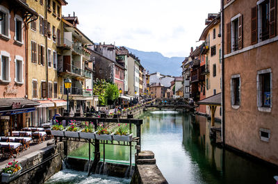 Canal in city against clear sky