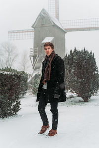 Portrait of young woman standing on snow field