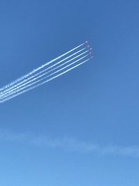 Low angle view of vapor trail against blue sky