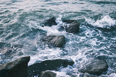 High angle view of waves hitting the rocks in sea