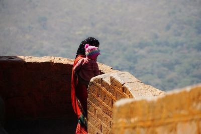 Woman standing with baby at observation point