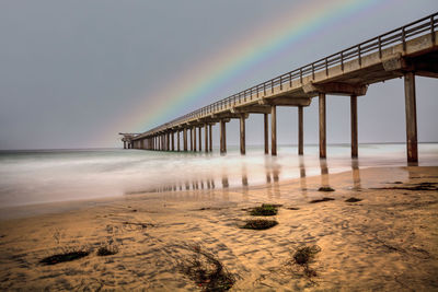 Rainbow over scripps pier beach in la jolla, california at the end of summer