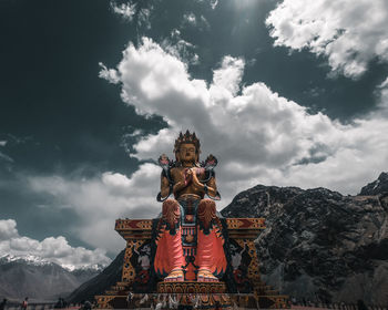 Low angle view of statue of temple against cloudy sky