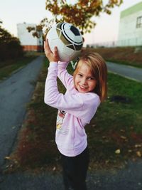 Portrait of smiling girl holding soccer ball 