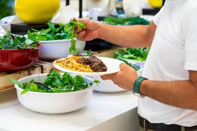 Midsection of man preparing food in kitchen