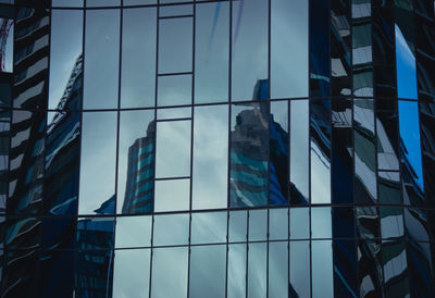 Low angle view of glass building against sky