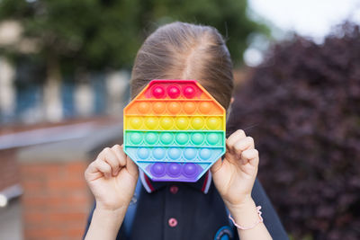 Close-up of girl holding multi colored toy