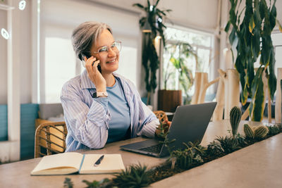 Businesswoman using laptop while sitting on table