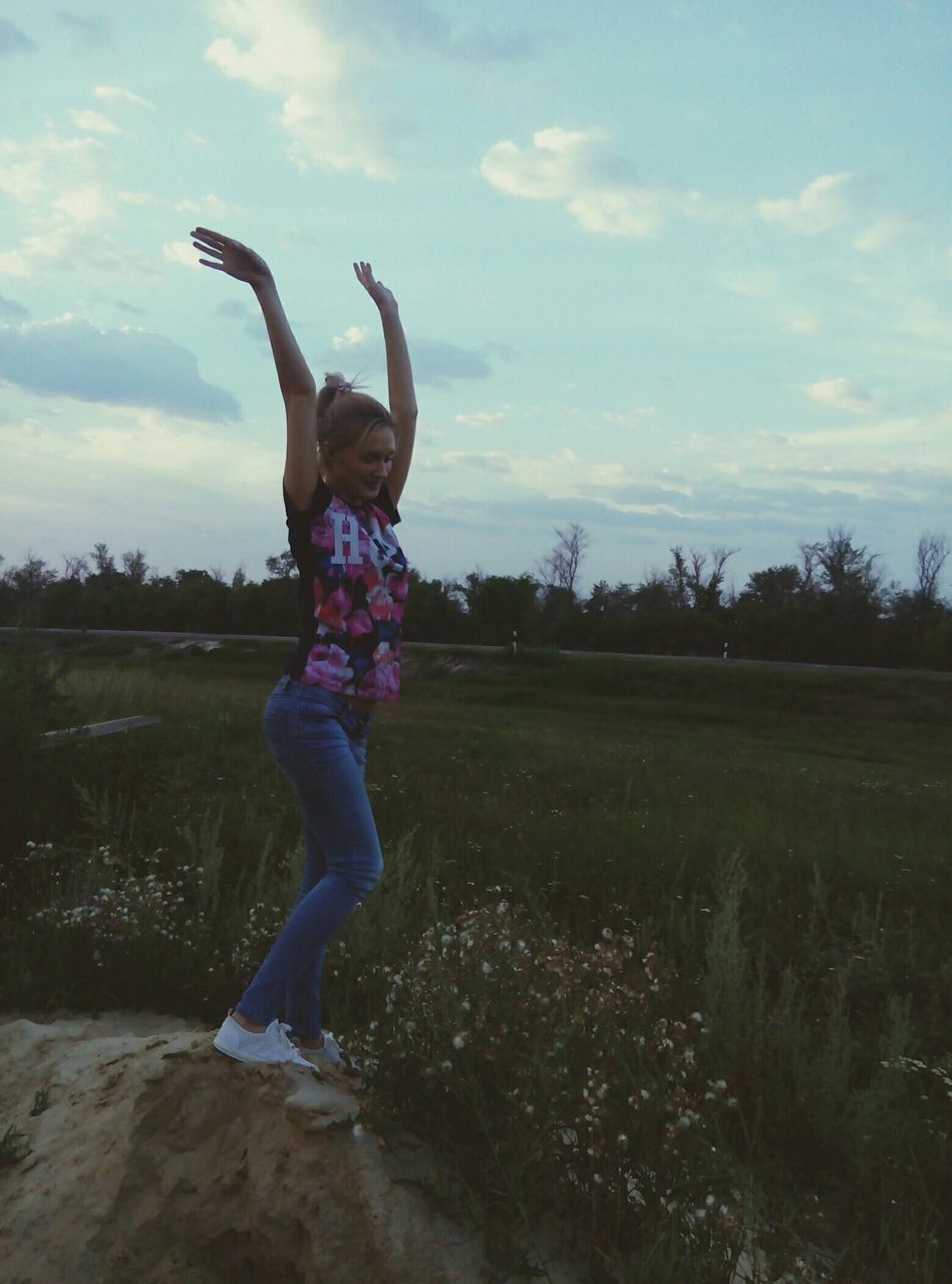 full length, sky, jumping, leisure activity, lifestyles, childhood, mid-air, person, casual clothing, arms raised, arms outstretched, grass, fun, elementary age, tree, field, carefree, girls