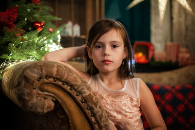 Portrait of girl sitting on sofa at home