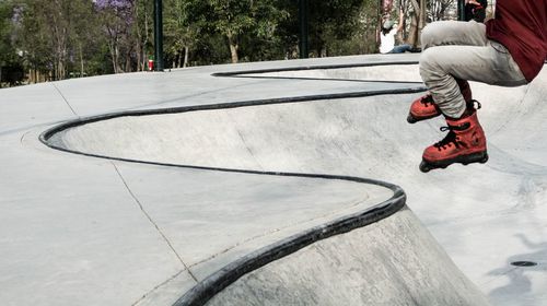 Low section of man roller skating at park