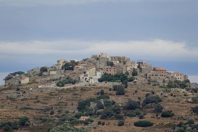 Village on hill against sky