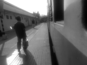 Rear view of man walking on road