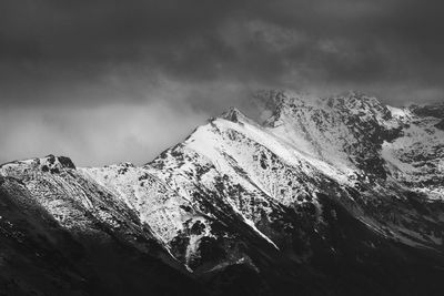 Low angle view of snowcapped mountains against sky