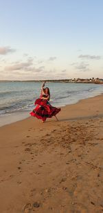 Smiling woman dancing at beach