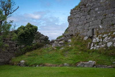 View of old ruin on field against sky