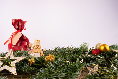 Close-up of christmas decorations on plant against white background