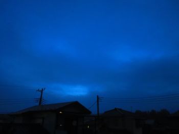 Low angle view of silhouette houses against sky at dusk