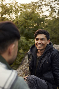 Young men sitting on rocks and talking