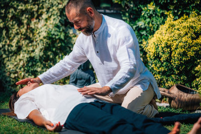 Close-up image of relaxed woman lying with her eyes closed and having reiki healing treatment 