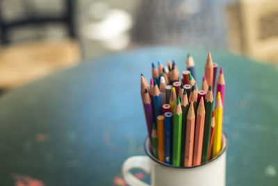 Close-up of colorful pencils in container on table