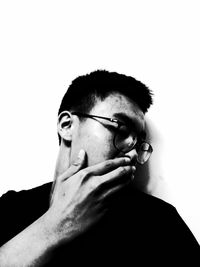 Close-up of man wearing eyeglasses against white background