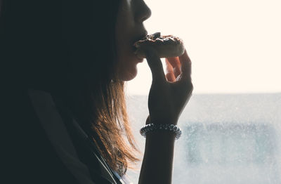 Midsection image of woman eating donut