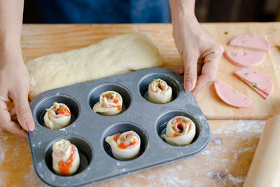 Cropped hands of woman preparing food in baking tray