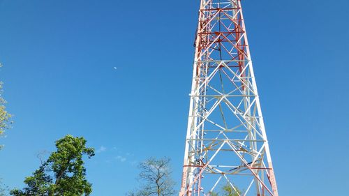 Low angle view of communications tower against blue sky