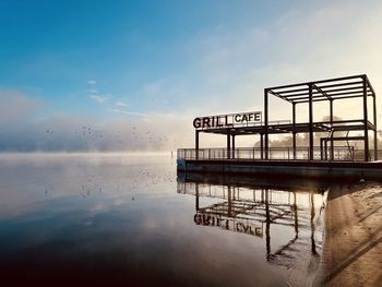 Pier over sea against sky during sunset