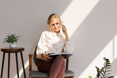 Attractive woman in business clothes with a smartphone in her hands, next