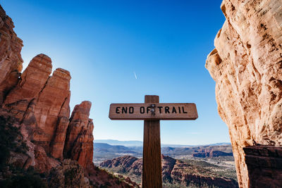 Information sign on rock against sky