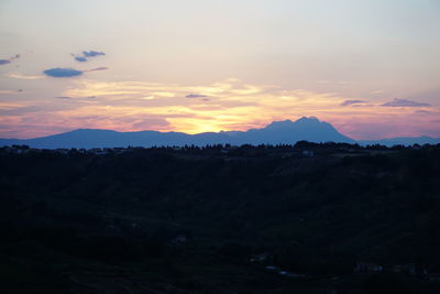 Scenic view of silhouette mountains against sky at sunset