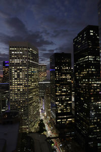 Illuminated buildings in city against sky at night