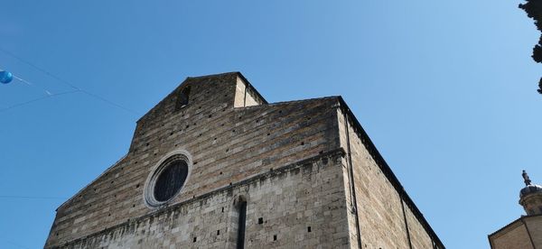 Low angle view of old building against clear blue sky