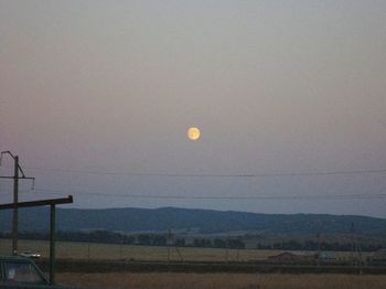 Scenic view of field against clear sky at dusk