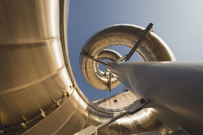 Directly below shot of spiral water slide against sky