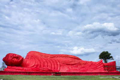 Red rock formations on field against sky