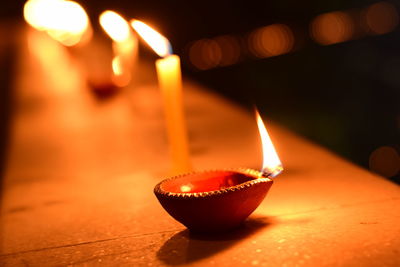 Close-up of lit diya on retaining wall