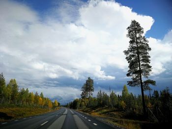 Road amidst trees against sky