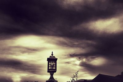 Low angle view of silhouette building against cloudy sky