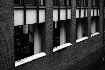 Side angle view of brick building with cut out windows and a view on the parking spaces inside